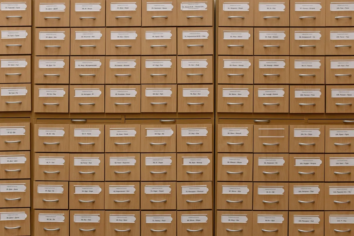 Rows of labeled wooden card catalog drawers in a library